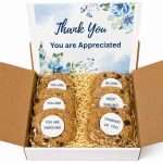 White gift box filled with gourmet cookies with inspirational messages and a large gift card