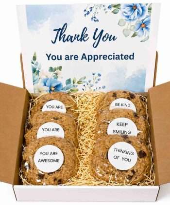 White gift box filled with gourmet cookies with inspirational messages and a large gift card