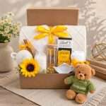 Cozy get well gift box with knitted blanket, teddy bear, herbal tea, chocolate, bath salts, glass tumbler, and comfort gifts.